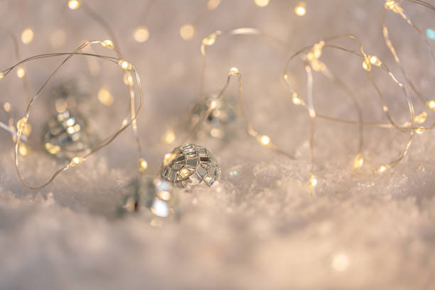 маленькие декоративные шарики с зеркалом и светящейся гирляндой на снегу. размытый праздничный серый фон с белым боке. - 4811 стоковые фото и изображения