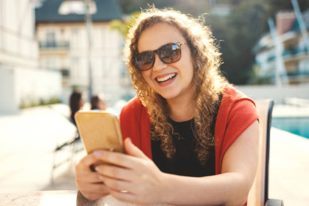 istock Young woman using cell phone near a pool 1158083432