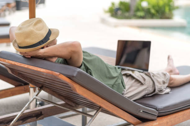Easy relax business man lifestyle with computer in hotel resort sitting hands behind head for happy businessman people with work life balance. Simplify Your Life Week. International happiness day. fácil de relajarse estilo de vida hombre de negocios con la computadora en el complejo hotelero sentado detrás de la cabeza para personas de negocios felices con equilibrio de vida laboral. simplifica tu semana de vida. día internacional de la felicidad