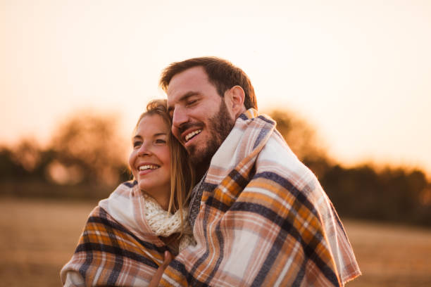 Couple wrapped in a blanket outdoors