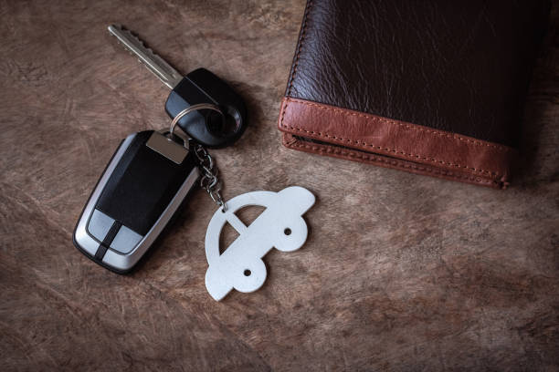 Car key with a car key chain. Head lights on. White background. This car is not a specific type of car.