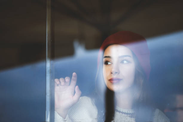 istock emotional woman looking out the window 1158086841