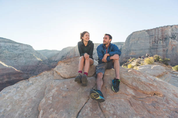 istock Young couple sitting together on a cliff 1158090176