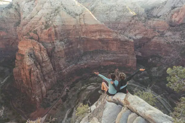 Photo of Two women hikers sitting on the edge of a cliff