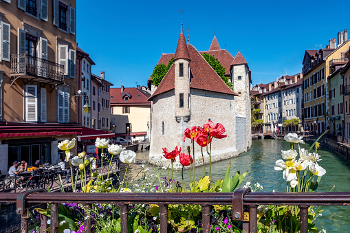 The Palais de l'Isle, Annecy, Haute-Savoie, France - May 19, 2019: 12th century castle on an island in the river Thiou in old town of Annecy.