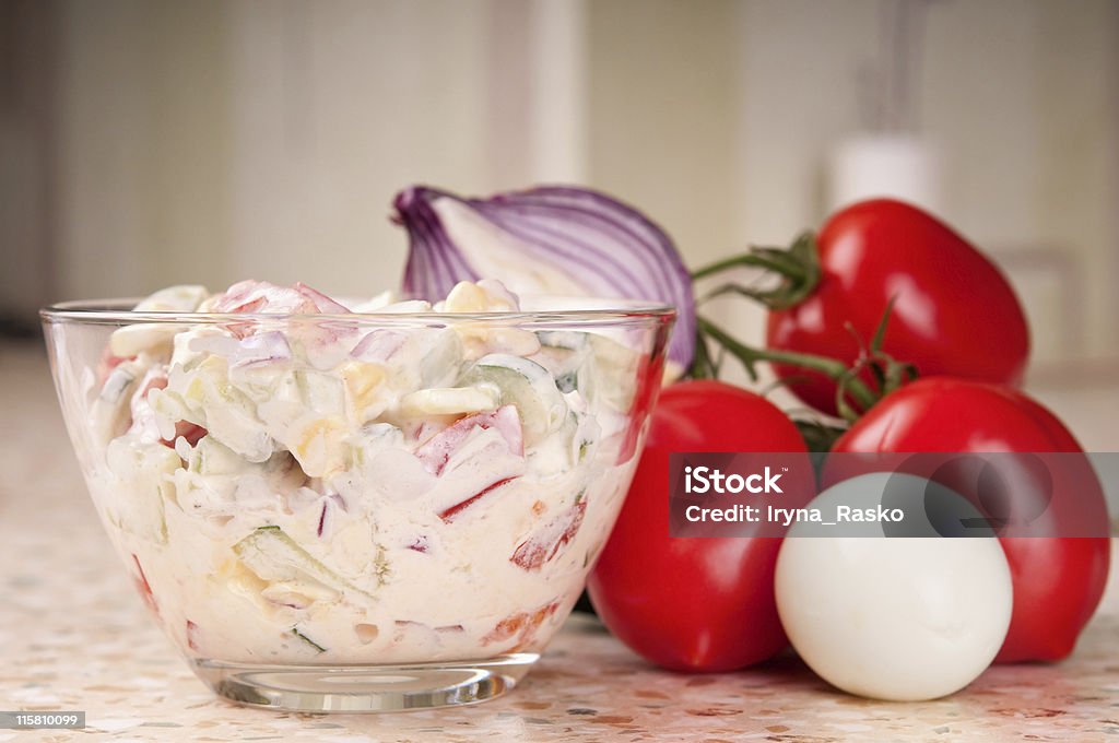 Fresh vegetable salad dressed with sour cream. Fresh salad with tomato, cucumber, onion and eggs dressed with sour cream Appetizer Stock Photo
