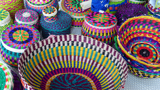 Handmade wicker baskets made from toquilla straw, vegetable fiber, and painted with various colors at craft market in Cuenca, Ecuador. Popular souvenir from Ecuador