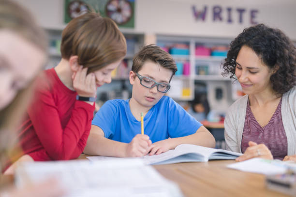 istock Teacher helping 4th graders in her classroom 1158104718