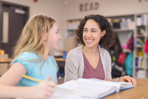 istock Teacher helping a 4th grader in her classroom 1158104719