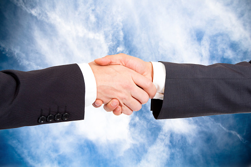 Two businessmen shake hands, partnership concept, closeup