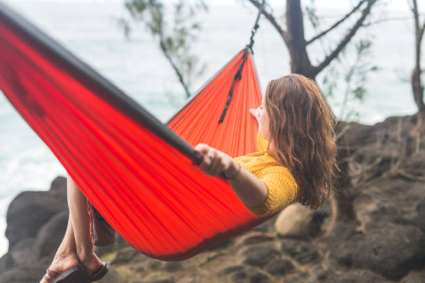 istock A single female relaxes in a hammock overlooking the ocean 1158107030