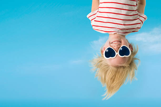 Hanging upside down is fun Young child wearing heart shaped sunglasses, carefree having fun hanging upside down. upside down stock pictures, royalty-free photos & images