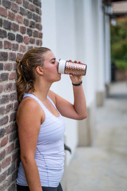 istock Young Woman Drinking From Reusable Coffee Cup After Working Out 1158109993