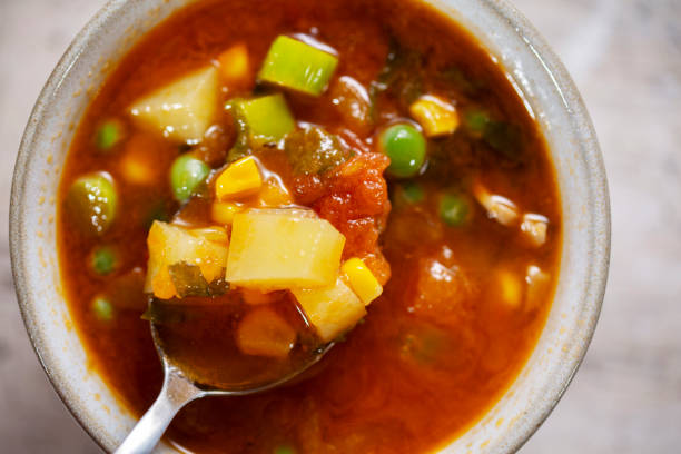 Soup in a clay bowl. Curried red lentil tomato and coconut soup - delicious vegetarian food. Served healthy lunch.