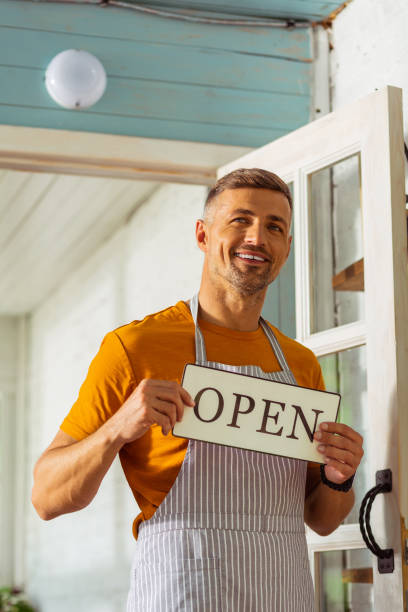 istock Happy smiling man opening his new shop. 1158116340