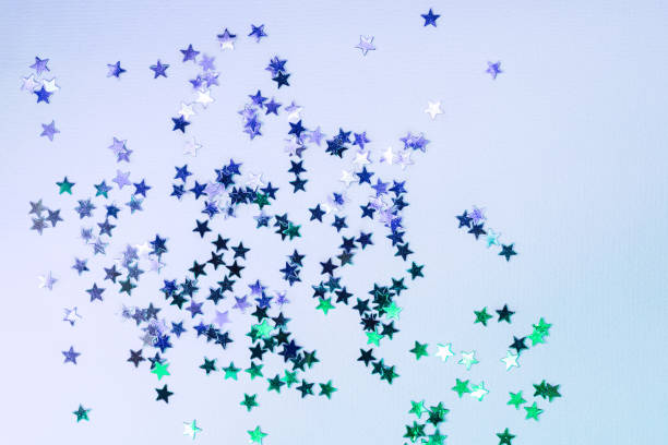 istock Holographic confetti stars on blue neon background 1158117445