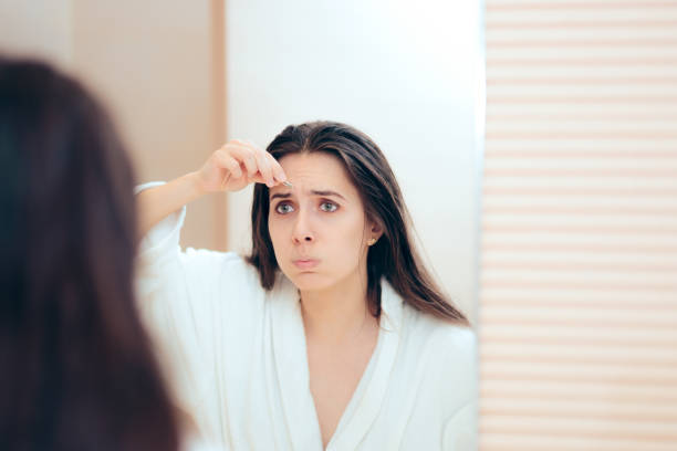istock Woman Wearing Bathrobe Plucking her Eyebrows After Shower 1158119729