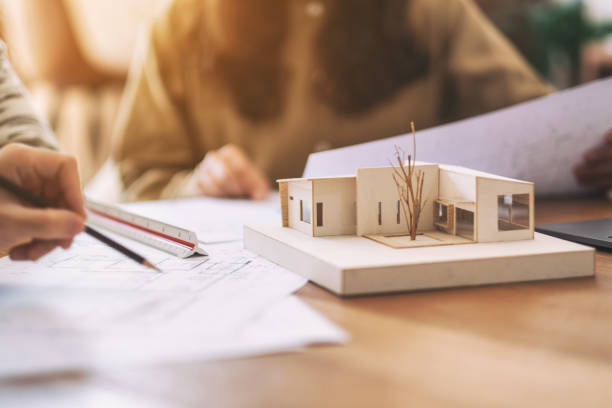istock an architect working and discussing about an architecture model together 1158122901