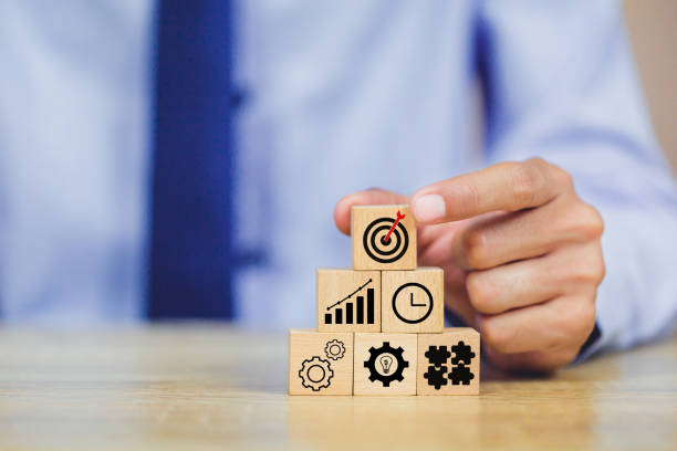 istock hands of busines hold a target with arrow,stacking wooden blocks into steps,Concept of business growth success 1158123932