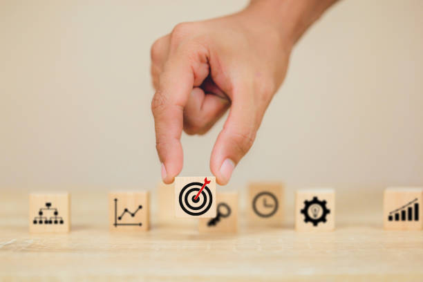 istock hands of busines hold a target with arrow,stacking wooden blocks into steps,Concept of business growth success 1158123948