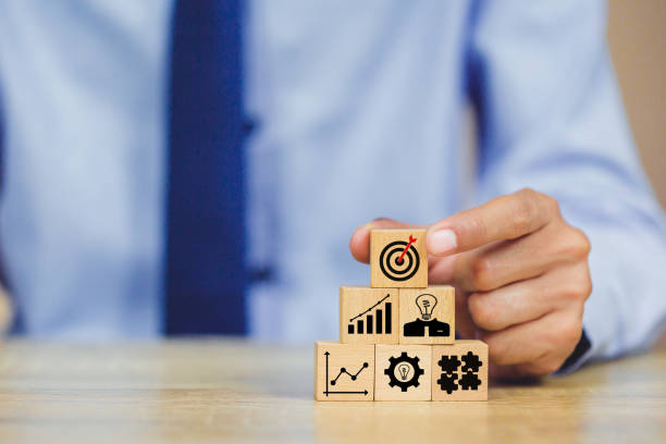 istock hands of busines hold a target with arrow,stacking wooden blocks into steps,Concept of business growth success 1158123976