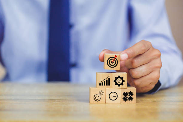 istock hands of busines hold a target with arrow,stacking wooden blocks into steps,Concept of business growth success 1158124012
