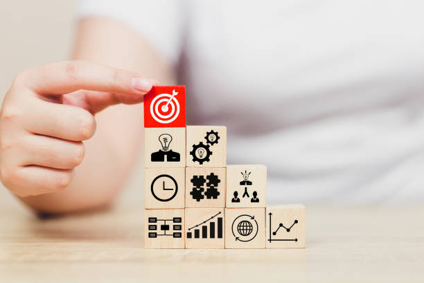 istock hands of busines hold a target with arrow,stacking wooden blocks into steps,Concept of business growth success 1158124569