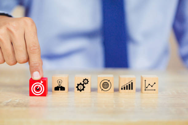 istock hands of busines hold a target with arrow,stacking wooden blocks into steps,Concept of business growth success 1158124618