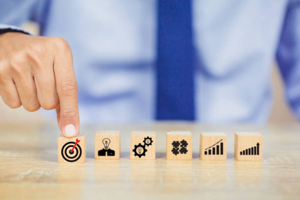istock hands of busines hold a target with arrow,stacking wooden blocks into steps,Concept of business growth success 1158124669