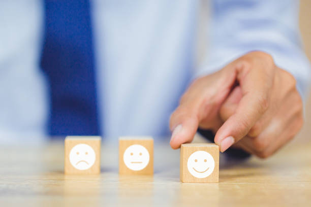 istock customer pressing smiley face emoticon on wood cube, Service rating, satisfaction concept. 1158126637