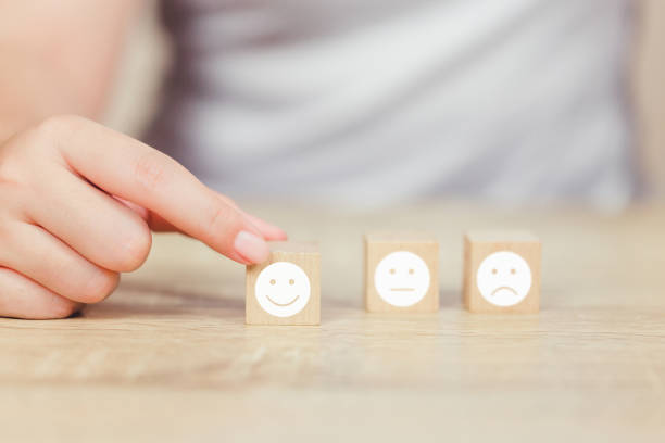 istock customer pressing smiley face emoticon on wood cube, Service rating, satisfaction concept. 1158126639