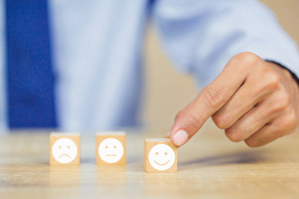 istock customer pressing smiley face emoticon on wood cube, Service rating, satisfaction concept. 1158126641