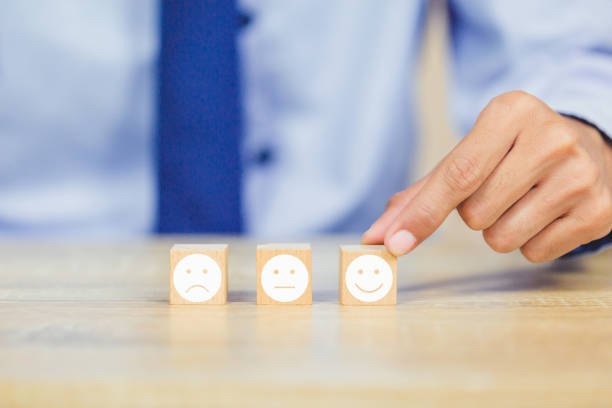 istock customer pressing smiley face emoticon on wood cube, Service rating, satisfaction concept. 1158126655