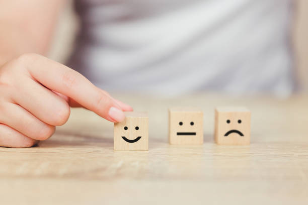 istock customer pressing smiley face emoticon on wood cube, Service rating, satisfaction concept. 1158126731