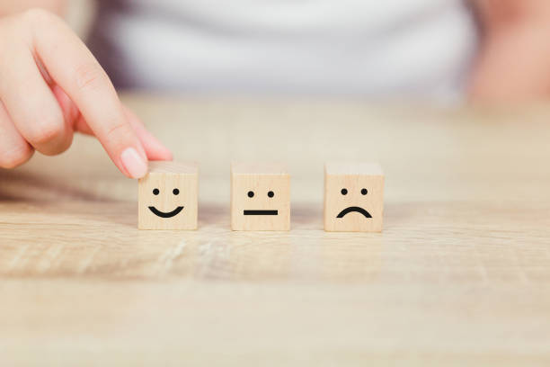istock customer pressing smiley face emoticon on wood cube, Service rating, satisfaction concept. 1158126761