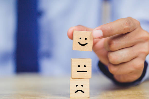 istock customer pressing smiley face emoticon on wood cube, Service rating, satisfaction concept. 1158126772
