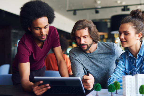 istock Young adult colleagues working with technology 1158127495