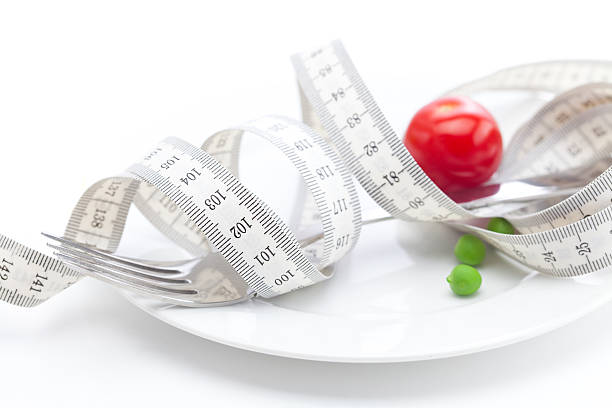 istock tomato,peas on plate and measure tape isolated  white 115812981