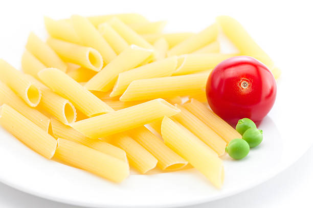 tomato, peas and pasta on a plate isolated on white
