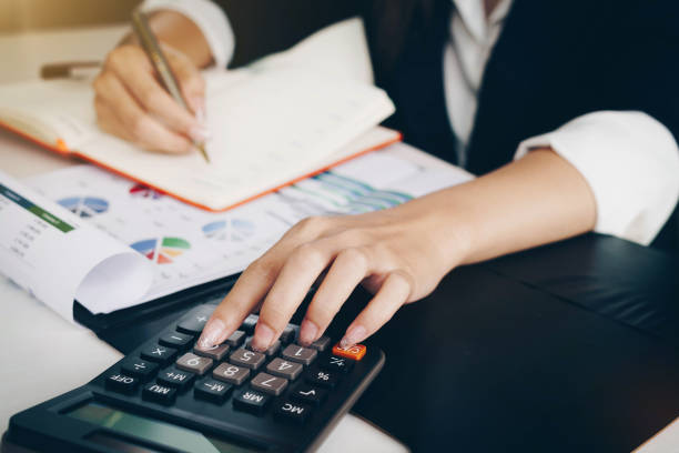 istock Businesswoman working with financial data hand using calculator and writing make note with calculate.Business financial and accounting concept. 1158130504