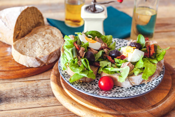istock Nicoise salad at dark bread slices at plate 1158130712