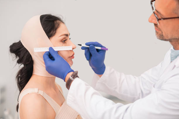 istock Bearded male plastic surgeon making face measurements 1158130739