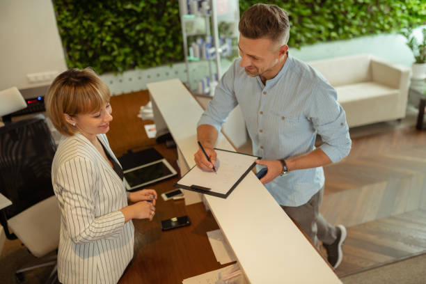 istock Handsome businessman smiling while talking to administrator at clinic 1158131613