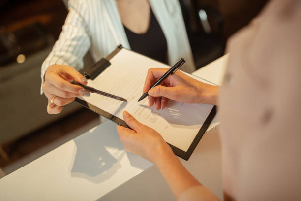 istock Woman holding pen while writing personal details in clinic 1158131638