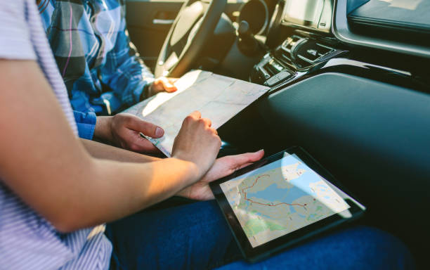 istock Couple comparing paper map and a gps navigator 1158136497
