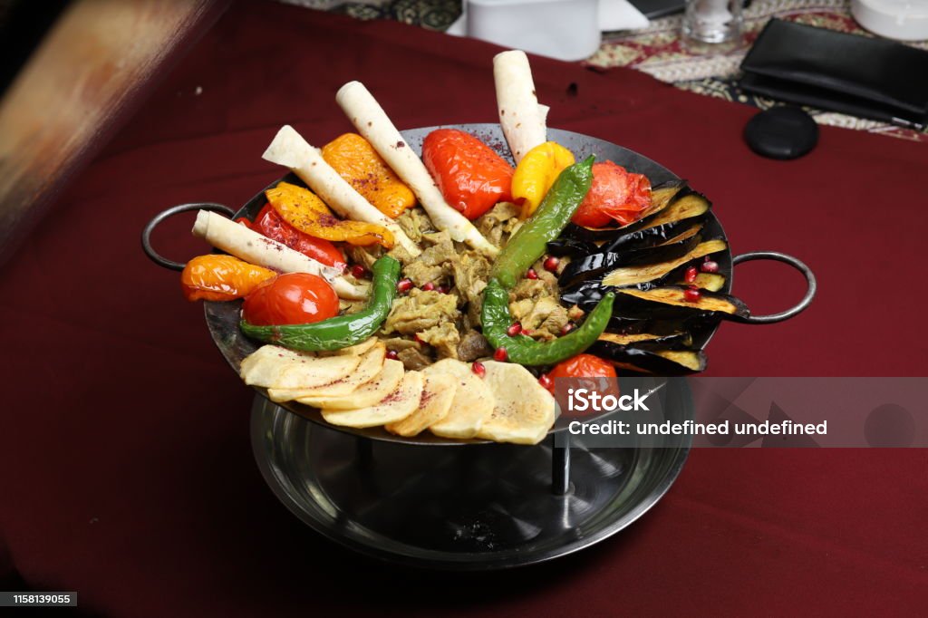 Caucasian traditional sac ici with fried potato, eggplant slices, tomatoes, pepper and beef stew. Caucasian traditional sac ici with fried potato, eggplant slices, tomatoes, pepper and beef stew. image Azerbaijan Stock Photo