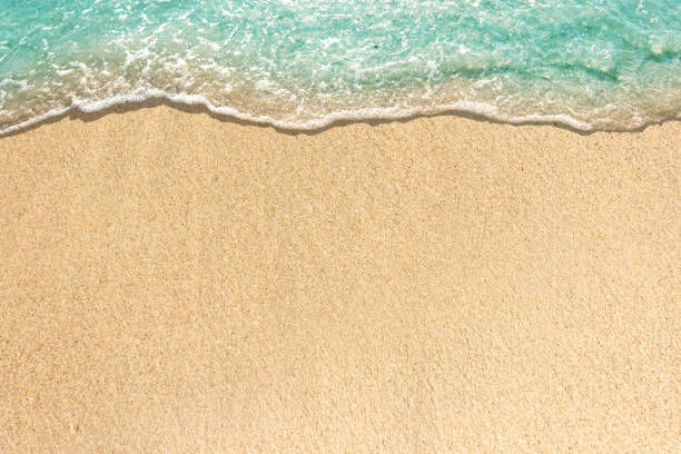 istock Soft waves with foam of blue ocean on the sandy beach 1158144856