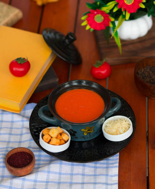 istock Tomato soup in a pot with chopped parmesan cheese and bread crackers. 1158147443