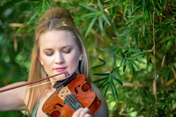 istock Beautiful Woman Playing Violin 1158148105