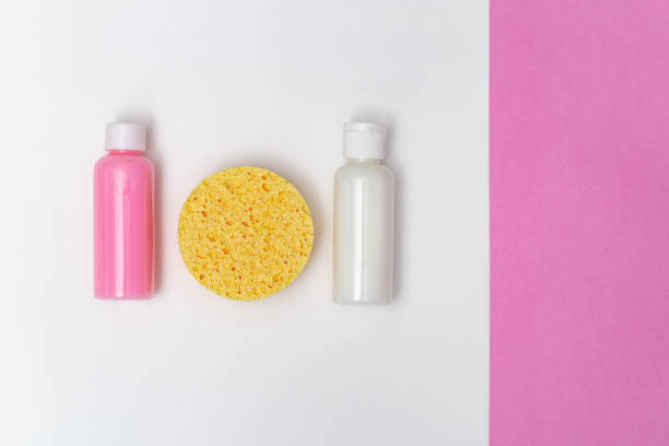 istock Face sponge yellow colored, moisturizer, cleanser in small bottles on paper background with copy space. Facial care. Beauty and skincare concept. Skin cleansing. Flat lay. Top view. 1158148630